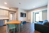 Located at 160 Sherwood Forest Square in London, Ontario, this single-floor unit offers four bedrooms and four bathrooms, making it an ideal multi-occupant residence. The open-concept kitchen and dining area serves as the heart of the unit, featuring two-tone cabinetry in soft blue-grey and white, a full suite of stainless steel appliances including a refrigerator, electric range, over-the-range microwave, and dishwasher, all set against a clean white tile backsplash and light countertops. Warm hardwood-style flooring runs throughout the space, adding cohesion and a welcoming feel. A wall-mounted TV in the dining area adds a functional communal touch. Each bedroom is a comfortable, private space with neutral walls and windows that allow natural light to filter in. The primary bedroom offers a generous footprint. The four bathrooms are finished with clean, modern fixtures, including glass-enclosed tile showers, white vanities, and wood-look flooring. A dedicated laundry area houses a stacked Whirlpool washer and dryer unit, providing added convenience. A hallway and closet complete the thoughtfully arranged layout of this practical and well-finished residential space.