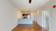 Located at 323 Brown St in West Lafayette, Indiana, this one-bedroom, one-bathroom unit offers a thoughtfully designed single-floor layout. The open-concept kitchen and living area forms the heart of the space, highlighted by rich hardwood-style flooring, soft neutral wall tones, and a ceiling fan that promotes comfortable airflow. The kitchen is well-appointed with dark cabinetry, granite countertops, a peninsula island with a built-in sink, and a full suite of stainless steel appliances including a refrigerator, range, microwave, and dishwasher. Three pendant lights hang above the island, adding a polished, functional accent. A sliding glass door floods the living area with natural light and provides an outdoor view. The bedroom is a comfortable, well-proportioned retreat featuring plush carpeting, a ceiling fan, and a window with blinds that allow for natural light and privacy. Two closets provide ample storage throughout the unit. A dedicated laundry area adds everyday convenience. The overall ambiance is clean, modern, and functional, making this a practical and attractive space in the West Lafayette area.