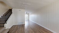 Located at 319 Imperial Beach Boulevard in Imperial Beach, CA, this two-story, 2-bedroom, 2-bathroom home is thoughtfully laid out across two evenly divided floors. The ground floor welcomes you with a bright, open living area showcasing rich wood-look flooring, a striking shiplap accent wall, and a ceiling fan that enhances airflow throughout. Natural light filters in through front-facing windows, creating a warm and inviting atmosphere. The kitchen is efficiently designed with white cabinetry offering generous storage, a gas range, refrigerator, and matching white appliances — all complemented by the same wood-look flooring. Upstairs, the two bedrooms are carpeted for comfort and feature windows with views of the surrounding neighborhood. The spacious primary bedroom includes a closet, while the second bedroom is equally well-sized with its own window and closet access. Both bathrooms are clean and functional, featuring white tile tub surrounds with chrome fixtures. A hallway connects the upstairs rooms efficiently. The overall design is clean and neutral, with a consistent white-and-warm-wood palette that gives the home a fresh, move-in-ready feel throughout.