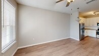 Located at 4595 Huntsman Drive in Kissimmee, Florida, this one-bedroom, one-bathroom residence offers a thoughtfully designed single-floor layout with a clean, modern aesthetic throughout. The open-concept living area features wood-look flooring, neutral warm-toned walls, and a ceiling fan, creating a bright and comfortable atmosphere. Large windows invite abundant natural light and provide views of the surrounding exterior, further enhancing the airy feel of the space.

The kitchen is a standout feature, showcasing crisp white shaker-style cabinetry, light granite-style countertops, and a full suite of stainless steel appliances including a refrigerator, electric range, built-in microwave, and dishwasher. Track lighting overhead ensures excellent visibility for cooking and meal prep.

The generously sized bedroom is finished with plush carpeting, a ceiling fan, and ample closet space including a walk-in closet. It connects conveniently to the bathroom, which offers a full tub-shower combination with white subway tile surround, a white vanity with granite-style countertops, and wood-look flooring that ties the space together cohesively.

Throughout the residence, neutral tones and consistent finishes create a harmonious, move-in-ready environment ideal for comfortable everyday living.