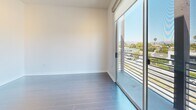 Located on N. Fairfax Avenue in the heart of West Hollywood, this modern 2-bedroom, 2-bathroom residence offers a thoughtfully designed single-level layout with contemporary finishes throughout. The open-concept living area is bathed in natural light, featuring large floor-to-ceiling windows that frame sweeping city and neighborhood views, complemented by plush wall-to-wall carpeting. The kitchen is a standout, equipped with stainless steel appliances including a gas range, built-in microwave, and French door refrigerator, all set against a sleek tile backsplash and dark cabinetry. A peninsula with a white countertop and stainless steel sink connects the kitchen to the living space, ideal for both cooking and entertaining. The primary bedroom is generously sized, featuring a mirrored sliding closet door and large windows that continue the theme of abundant natural light and urban views. The second bedroom also enjoys ample natural light with sliding glass door access. Both bathrooms are finished with large-format tile flooring and dark wood vanities; one features a glass-enclosed walk-in shower. The clean, neutral palette and modern architectural detailing create a cohesive and sophisticated ambiance throughout this well-appointed West Hollywood residence.