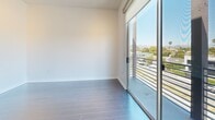 Located on N. Fairfax Avenue in the heart of West Hollywood, this modern 2-bedroom, 2-bathroom residence offers a thoughtfully designed single-level layout with contemporary finishes throughout. The open-concept living area is bathed in natural light, featuring large floor-to-ceiling windows that frame sweeping city and neighborhood views, complemented by plush wall-to-wall carpeting. The kitchen is a standout, equipped with stainless steel appliances including a gas range, built-in microwave, and French door refrigerator, all set against a sleek tile backsplash and dark cabinetry. A peninsula with a white countertop and stainless steel sink connects the kitchen to the living space, ideal for both cooking and entertaining. The primary bedroom is generously sized, featuring a mirrored sliding closet door and large windows that continue the theme of abundant natural light and urban views. The second bedroom also enjoys ample natural light with sliding glass door access. Both bathrooms are finished with large-format tile flooring and dark wood vanities; one features a glass-enclosed walk-in shower. The clean, neutral palette and modern architectural detailing create a cohesive and sophisticated ambiance throughout this well-appointed West Hollywood residence.