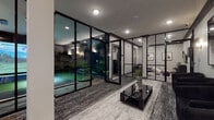 Located at 8 Tice Rd in Franklin Lakes, NJ, this single-floor entertainment facility is thoughtfully designed to deliver a premium recreational experience. The space is defined by a striking contemporary aesthetic, anchored by floor-to-ceiling black-framed glass partition walls that divide the various zones while maintaining a sense of openness and visual connectivity throughout.

The centerpiece of the facility is a state-of-the-art indoor golf simulator room, complete with a full driving bay, a large projection screen displaying realistic course imagery, a putting green with synthetic turf, and golf-themed wall murals. The simulator bay is equipped with professional lighting and a dedicated mini-split HVAC unit for climate control.

Adjacent to the golf simulator, a sophisticated lounge area features textured carpet flooring, a sleek black coffee table, and comfortable seating arranged for socializing. The lounge connects seamlessly through the glass partitions to a smaller secondary seating area furnished with a wall-mounted display and a credenza, accented by a decorative indoor plant.

A dedicated screening room rounds out the facility, outfitted with a row of premium black leather power recliner seats featuring illuminated cup holders and blue LED accent lighting beneath. A large wall-mounted television anchors the room, while a wall sconce and mini-split unit complete the cinema-like atmosphere. Throughout the space, recessed lighting and carefully placed wall sconces create a polished, upscale ambiance.