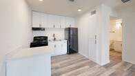 This 390 square foot apartment in Fort Worth, TX offers a thoughtfully designed living space with modern amenities. The single-floor layout comprises one bedroom (110 sq ft), one bathroom, a kitchen, and a closet. The interior is characterized by its bright, airy ambiance, enhanced by white walls and ample natural light from windows with blinds.

The flooring throughout is a stylish wood-look material, adding warmth and durability to the space. The bedroom features a ceiling fan for comfort and air circulation. The kitchen is equipped with sleek white cabinetry, black appliances including a refrigerator and stove, and a convenient island or peninsula for additional counter space.

The bathroom, while compact, includes a full-sized bathtub with a shower, and is finished in clean, white tones. The apartment's design maximizes the use of its 390 square feet, creating a cozy yet functional living environment. With its modern finishes and efficient use of space, this apartment offers a comfortable home in a desirable Fort Worth location.