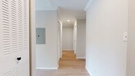This thoughtfully updated 2-bedroom, 2-bathroom apartment offers 1,050 square feet of single-floor living space designed with a clean, modern aesthetic. Light wood flooring runs throughout the unit, complemented by crown molding and neutral toned walls that create a bright, cohesive atmosphere. The open kitchen is equipped with warm wood cabinetry featuring matte black hardware, stainless steel appliances including a gas range, microwave, dishwasher, and a large French door refrigerator, all set against a white tile backsplash. In-unit washer and dryer hookups are conveniently located adjacent to the kitchen. The spacious living room receives ample natural light and provides direct access to a private balcony overlooking surrounding greenery and neighborhood views. Both bedrooms feature light wood flooring, ceiling fans, crown molding, and louvered sliding closet doors. The primary bedroom measures 180 square feet, offering generous space. Each bathroom is finished with white tile surrounds, wood vanities with white countertops, and matte black fixtures and hardware. A dedicated closet provides additional storage. The unit presents a well-balanced combination of modern updates and functional layout throughout.
