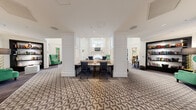 Located at 750 Thornton Way in Alexandria, Virginia, this sophisticated single-floor clubhouse showcases a refined blend of classic architectural details and bold contemporary design. The grand entry foyer sets a distinguished tone with an intricate parquet wood floor inlaid with contrasting geometric borders, flanked by stately white columns and anchored by a striking navy drum pendant light overhead.

The expansive main lounge features soaring ceilings adorned with sculptural gold geometric pendant fixtures, crisp white wainscoting panels, and plush patterned carpeting throughout. A statement marble fireplace serves as the room's focal point, framed by elegant millwork and topped with a mounted television, while tufted accent chairs in contrasting tones invite relaxed seating nearby.

A dedicated conference or meeting area offers a central work table surrounded by black chairs, set within a paneled alcove framed by tall architectural columns. Adjacent, a vibrant library lounge draws the eye with deep emerald-green walls, dark built-in shelving displaying curated artwork, a tufted teal velvet sofa, and cognac leather armchairs atop a bold black-and-white geometric rug.

The formal dining room continues the emerald palette with vivid green walls, a dramatic black-and-gold pendant light, and a round dark-lacquered dining table surrounded by tall upholstered ivory chairs. Throughout, gold accents, art glass panels, and layered textiles unify the space with a cohesive, upscale aesthetic.
