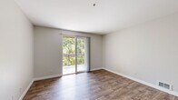 Located at 1230 Shaffer Rd in Santa Cruz, California, this well-appointed 3-bedroom, 2-bathroom residence offers a thoughtfully designed single-floor layout. The living room is a bright, welcoming space featuring rich hardwood-style flooring and sliding glass doors that open onto a private balcony overlooking lush, mature trees — bringing natural light and serene greenery indoors.

The kitchen is a functional highlight, outfitted with crisp white cabinetry, granite-style countertops, a breakfast bar peninsula, and a full suite of stainless steel appliances including a refrigerator, range, microwave, and dishwasher. Wood-look flooring extends throughout the kitchen and living areas, lending a cohesive and clean aesthetic.

The spacious primary bedroom continues the hardwood-style flooring and also features direct balcony access through sliding glass doors, offering tranquil outdoor views. The additional bedrooms are carpeted and finished with neutral tones, providing comfortable, versatile spaces. Closets are equipped with wire shelving for practical storage.

Both bathrooms are finished with granite-topped white vanities and tub-shower combinations with chrome fixtures, maintaining a consistent, clean design throughout. The neutral color palette and modern finishes create a bright, move-in-ready atmosphere suited for comfortable everyday living in the heart of Santa Cruz.
