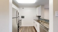 Located on the seventh floor at 4849 Connecticut Ave NW in Washington, DC, this one-bedroom, one-bathroom unit offers a well-organized layout across a single floor. The entry hallway welcomes you in, with a pass-through to the kitchen and access to multiple closets for ample storage throughout the unit. The kitchen is thoughtfully updated, featuring white shaker cabinetry, granite countertops, a mosaic tile backsplash, stainless steel appliances including a refrigerator, range, microwave, and dishwasher, as well as wood-look plank flooring and a skylight-style overhead fixture that keeps the space bright. A peninsula counter opens toward the hallway, creating an efficient flow into the combined dining and living area. The living room benefits from a large floor-to-ceiling window that invites natural light and offers outward views of the surrounding neighborhood. Wood-style flooring extends throughout the main living spaces. The bedroom is a comfortable, private retreat with its own closet and hardwood-style floors. The bathroom includes a full tub and shower combo with white tile surround, maintaining a clean and classic aesthetic. This unit offers practical, modern living in a prime Northwest DC location.