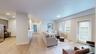 Located at 724 E Hastings Rd in Spokane, WA, this single-floor unit offers a thoughtfully designed layout with 1 bedroom, 2 bathrooms, a dedicated office, and an attached garage. The open-concept kitchen and living room serve as the heart of the home, where light wood-tone flooring flows throughout, complemented by a textured ceiling and recessed lighting. The kitchen is outfitted with wood-grain cabinetry, stainless steel appliances, and clean white countertops. The living area is bright and airy, featuring large windows with slatted blinds that invite natural light and offer outdoor views. The generously sized primary bedroom features plush carpeting and a calm, neutral palette, while the primary bathroom impresses with a long vanity, warm wood cabinetry, a wide mirror, and an adjacent walk-in closet with wire shelving. The dedicated office provides a carpeted, windowed retreat well-suited for focused work. A walk-through hallway connects all spaces efficiently. The attached garage offers a clean, enclosed space with an automatic opener. Throughout, the design balances modern aesthetics with practical livability, creating a comfortable and cohesive environment.