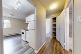 This well-appointed one-bedroom, one-bathroom unit in Abbotsford, BC, offers a practical and comfortable layout across a single floor. Throughout the unit, durable grey-toned vinyl plank flooring ties the spaces together with a clean, modern aesthetic, complemented by neutral warm-grey walls and textured ceilings.

The kitchen is efficiently designed with white cabinetry, a full-size refrigerator, and an electric range. A built-in hallway storage unit and a bifold closet door provide ample organizational space, keeping the unit tidy and functional. Track lighting in the kitchen area ensures the workspace is well-lit.

The living room is generously proportioned and features a sliding glass door that opens to an outdoor patio area, allowing natural light to fill the room and offering views of surrounding greenery. Baseboard heaters are present throughout, providing reliable warmth.

The bedroom is a comfortable, well-sized room with a window framing tree-lined outdoor views, a baseboard heater, and access to additional closet storage.

The bathroom is thoughtfully finished with wood-look flooring, large-format grey wall tiles surrounding the soaker tub and shower combination, a dark granite-topped vanity with white cabinetry, and a mirrored medicine cabinet with vanity lighting. This unit combines functional design with modern finishes throughout.