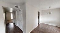 Located at 605 Catalina Dr in Waco, Texas, this single-story home offers a straightforward and functional layout with consistent finishes throughout. Dark hardwood-style flooring runs through the main living areas, hallways, and kitchen, providing a cohesive look across the home.

The living and dining areas are bright and open, benefiting from large windows dressed with horizontal blinds that allow natural light to fill each room. The dining area features a simple chandelier overhead and a textured ceiling, lending a classic character to the space.

The galley-style kitchen is efficiently designed with white cabinetry lining both sides, light countertops, and white appliances including a refrigerator, range, and built-in microwave. A textured ceiling continues here, and dark flooring grounds the space.

The bedrooms are carpeted and comfortably sized, each featuring ceiling fans with light fixtures and windows that bring in natural light. The neutral wall tones and textured ceilings carry throughout these rooms as well.

The bathrooms are well-appointed, featuring white cabinetry with ample storage, framed mirrors, warm-toned countertops, dark hardwood-style flooring, and brushed nickel hardware and fixtures. One bathroom includes a tiled shower, while another offers a combination tub and shower.

Overall, the home presents a clean, neutral palette well-suited for comfortable everyday living.