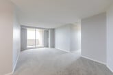 Located at 1850 Rathburn Rd E in Mississauga, this 3-bedroom, 1-bathroom unit offers a practical and well-organized layout across a single floor. The open living and dining area is finished with soft grey carpeting and neutral-toned walls, creating a clean, versatile backdrop. A elegant chandelier adds a touch of warmth to the living space, which connects seamlessly to the kitchen through an open passageway. The kitchen features warm oak cabinetry, white countertops, tile flooring, and a window that frames elevated views of the Mississauga skyline and surrounding greenery. Appliances include a white electric range and a built-in dishwasher. The three bedrooms are carpeted and finished in light grey tones, each offering a calm and functional space. The primary bedroom is generously sized with ample room for furnishings, while one secondary bedroom features sliding wood-panel closet doors. Large windows throughout the unit fill the rooms with natural light and provide impressive elevated views of the neighbourhood below. The full bathroom includes a tiled tub-shower combination with chrome fixtures in a clean, all-white finish. Two hallways connect the rooms efficiently, completing the thoughtful layout of this well-lit Mississauga residence.