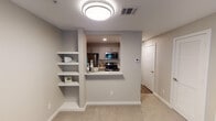 Located at 2825 Parkview Ln in Bedford, Texas, this two-story residence offers a well-organized layout with functional design details throughout. The entry level welcomes visitors with a carpeted living area bathed in natural light from multiple windows, a ceiling fan overhead, and a staircase leading to the upper floor. The kitchen is thoughtfully designed with gray shaker-style cabinetry, white subway tile backsplash, white quartz countertops, and a full suite of stainless steel appliances including a refrigerator, range, microwave, and dishwasher. A pass-through window connects the kitchen to the living area, enhancing the open feel of the space. Built-in wall shelving in the living area provides convenient display and storage options. The carpeted bedrooms are generously sized with natural light from windows and neutral-toned walls. The primary bathroom features wood-look flooring, a long vanity with gray cabinetry, white countertops, a large mirror with modern lighting, and a double sliding closet door offering ample storage. A secondary bathroom includes a full soaking tub and shower combination with large-format tile surround. Throughout the home, a consistent neutral color palette, modern fixtures, and a smart thermostat contribute to a clean, contemporary living environment.