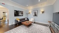Located at 216 S Orange Dr in the heart of Los Angeles, this two-story, 3-bedroom, 3-bathroom home offers a well-designed layout across two floors. The main level features a welcoming living room with dark hardwood floors, soft blue-gray walls, recessed lighting, and natural light from front-facing windows. The kitchen is a standout, boasting cream cabinetry, dark granite countertops, a center island with seating, travertine tile flooring, and an elegant wrought-iron chandelier, with French doors leading to the exterior. A dedicated dining room provides additional gathering space. The laundry room is equipped with modern appliances, cabinetry, and a window. Upstairs, the generously sized primary bedroom features crown molding, patterned carpet, a ceiling fan, and access to a walk-in closet. Additional bedrooms include vaulted ceilings and wood-blind windows. The bathrooms are elegantly appointed, with one featuring a travertine vessel sink, soaking tub, and glass-enclosed shower with mosaic tile accents. Seven closets distributed throughout the home ensure abundant storage. The property also includes a versatile bonus room with hardwood floors, a Sputnik-style chandelier, and multiple windows offering views of the surrounding greenery.