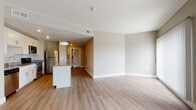 Located at 430 Warren St in Dayton, Ohio, this single-floor residence offers a thoughtfully designed open-concept layout that seamlessly connects the kitchen, dining, and living areas. The kitchen is a functional centerpiece, featuring white shaker-style cabinetry, dark countertops, a full suite of stainless steel appliances including a refrigerator, range, microwave, and dishwasher, and a central island with pendant lighting overhead. Light wood-look luxury vinyl flooring runs throughout the main living areas, adding warmth and continuity to the space. The living area is generously proportioned and bathed in natural light, with access to a balcony that offers pleasant outdoor views of the surrounding greenery. The bedrooms are finished with plush carpeting and feature large windows that continue to bring in natural light; one bedroom includes a spacious walk-in closet. The bathrooms are well-appointed with wood-look flooring, a tub-shower combination, white vanity cabinetry, and a wall-mounted mirror. One bathroom also includes accessibility grab bars. Neutral gray tones throughout the unit create a clean, contemporary ambiance that is both inviting and versatile.