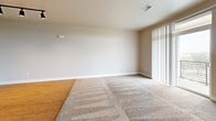 Located at 6720 W 29th St in Greeley, Colorado, this well-appointed single-floor home offers three bedrooms, two bathrooms, and a thoughtfully designed layout. The open-concept kitchen and living area serves as the heart of the home, featuring warm wood cabinetry, granite countertops, black appliances including a refrigerator, range, and built-in microwave, and a central island with bar seating. Track lighting illuminates the space, which transitions seamlessly from hardwood flooring in the kitchen into a carpeted living area with access to a private balcony through sliding glass doors fitted with vertical blinds. The spacious primary bedroom includes a walk-in closet and is accompanied by two additional bedrooms, each featuring plush carpeting, natural light from windows with blinds, and sliding-door closets. Both bathrooms are finished consistently with granite-topped vanities, warm wood cabinetry, tile flooring, and full tub-shower combinations. Neutral warm tones throughout the home create a cohesive and inviting ambiance, while the functional floor plan makes efficient use of space across every room.