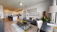 This well-appointed single-floor residence offers a thoughtfully designed open-concept layout that seamlessly connects the kitchen, dining, and living areas. The kitchen is a standout feature, boasting crisp white shaker cabinetry, stainless steel appliances including a range and built-in microwave, and a generous granite-topped island with bar seating and elegant pendant lighting — ideal for both casual dining and entertaining. Light wood-style flooring flows throughout the main living areas, enhancing the bright and airy atmosphere.

The living room is a comfortable and stylish retreat, featuring large windows that invite abundant natural light and offer outdoor views. A ceiling fan adds a practical touch, while the open sightlines to the kitchen create an inclusive, connected feel.

The bedrooms are carpeted for warmth and comfort, each accented with a soothing blue-gray feature wall and ceiling fans. Natural light filters through well-sized windows, contributing to a calm and restful ambiance.

The primary bathroom is elongated and well-lit, featuring white cabinetry with granite countertops, dual sinks, and light tile flooring. The secondary bathroom mirrors the same design language with white cabinetry, granite counters, and a tub-shower combination. The overall aesthetic throughout is modern, cohesive, and move-in ready.