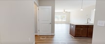 Located at 23 Encanto Ln, Unit 106, in Rustburg, Virginia, this well-appointed single-floor unit offers 950 square feet of thoughtfully designed living space with 2 bedrooms and 2 bathrooms. The open-concept kitchen and living room serve as the heart of the home, featuring light wood-look vinyl flooring, a ceiling fan, and large windows that invite abundant natural light. The kitchen is equipped with rich wood cabinetry, stainless steel appliances including a refrigerator, range, and microwave, and a peninsula with a white countertop and double sink, illuminated by pendant lighting above. Both bedrooms are carpeted and feature ceiling fans and windows with outdoor views. The primary bedroom spans 140 square feet and includes a walk-in closet outfitted with wire shelving for ample storage. Both bathrooms are finished with wood-look vinyl flooring, wood vanity cabinetry, white countertops, and full tub-shower combinations with brushed nickel fixtures. Neutral warm beige tones throughout the unit create a cohesive, move-in-ready aesthetic. Clean lines, consistent finishes, and plentiful natural light define the overall ambiance of this functional and comfortable residence.