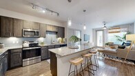 Located in Allen, TX, this well-appointed 2-bedroom, 2-bathroom residence offers a thoughtfully designed single-floor layout that maximizes both function and comfort. The heart of the home is a seamless open-concept kitchen, dining, and living area. The kitchen is a standout, featuring rich dark cabinetry with a subway tile backsplash, stainless steel appliances, granite countertops, and a large central island with pendant lighting and bar seating — ideal for casual dining or entertaining. Wood-style flooring flows throughout the main living area, which is bright and airy with ceiling fan and access to natural light from large windows. Both bedrooms are carpeted and comfortably sized, each benefiting from natural light and ceiling fans. The primary bedroom connects to a private ensuite bathroom with granite vanity, a walk-in shower, and a spacious walk-in closet with built-in shelving. The second bathroom also features granite countertops and a tub-shower combo. Additional highlights include five closets offering abundant storage, a dedicated pantry, an in-unit laundry area, and track lighting throughout the kitchen. The overall ambiance is modern and inviting, with clean finishes and a cohesive neutral palette throughout.