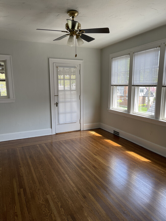 Newly refinished hardwood floors highlight this sunny living room with access to the balcony. - 3863 Marburg Ave