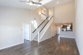 Located at 6401 Sandstone Dr in Midland, Texas, this two-story home offers a thoughtfully designed layout with consistent, quality finishes throughout. The kitchen is a standout feature, showcasing rich dark-stained cabinetry, light granite countertops, a subway tile backsplash, and stainless steel appliances including a double oven range, dishwasher, and a wall-mounted range hood. Globe pendant lights add a contemporary touch above the sink area, while wood-style flooring ties the space together seamlessly.

The living and dining areas continue the wood-style flooring and are characterized by notably tall ceilings that contribute to an open, airy atmosphere. Large French doors in the living area invite natural light and provide views to the outdoors. A half bath on the main level features a pedestal sink and clean, minimal finishes.

Upstairs, the bedrooms are carpeted and benefit from natural light through blinded windows. The bathrooms include a full bath with a tub-shower combo lined in white subway tile, and a second bathroom featuring dark cabinetry, granite countertops, tile flooring, and overhead storage. Throughout the home, neutral tones and consistent detailing create a cohesive and move-in-ready environment.