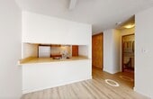 Located at 11104 84 Ave NW in Edmonton, Alberta, this efficiently designed one-bedroom, one-bathroom unit offers a thoughtful layout across a single floor. The living area is a standout feature, anchored by a large bay window that floods the space with natural light and is complemented by light-toned vinyl plank flooring and a ceiling fan overhead, creating a bright and airy atmosphere. A textured ceiling adds a classic character throughout the unit.

The galley-style kitchen is well-equipped with warm wood cabinetry on both sides, ample upper and lower storage, and full white appliances including a refrigerator, electric range, dishwasher, and double sink — making it a functional space for everyday cooking.

The bedroom offers a comfortable footprint with light grey vinyl flooring, a baseboard heater, and a window dressed with curtains. A built-in sliding-door closet with integrated shelving provides practical storage. The bathroom features full tile surround on the tub-shower combination, clean white fixtures, and an over-toilet storage cabinet.

A connecting hallway ties the rooms together efficiently, and the unit includes an intercom panel near the entry. The overall palette of whites and natural wood tones lends a clean, neutral aesthetic throughout.
