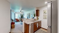 Located in Chisago City, Minnesota, this 2-bedroom, 1-bathroom residence offers a well-designed single-floor layout that balances comfort and functionality. The open-concept kitchen is outfitted with warm wood cabinetry, granite-style countertops, stainless steel appliances, and light hardwood flooring. A peninsula with bar seating connects the kitchen seamlessly to the living area, making the space ideal for entertaining. The living room is generously sized, featuring a ceiling fan, large windows, and direct access to an outdoor patio that overlooks a peaceful pond and lush green lawn — a standout feature of this home. Both bedrooms are carpeted and receive natural light through well-positioned windows. The primary bedroom is a comfortable retreat, large enough to accommodate a full bedroom suite, with views of the surrounding greenery. The second bedroom includes a dedicated closet and easy hallway access. The full bathroom features rich wood vanity cabinetry, a wide mirror with lighted surround, and hardwood-style flooring. Dark wood trim and baseboards carry throughout the home, providing a cohesive and polished finish. The overall ambiance is warm, clean, and inviting — well-suited for those seeking a quiet residential setting with scenic outdoor surroundings.