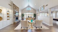 Located at 800 Hydric Ct in Odenton, Maryland, this thoughtfully designed single-floor clubhouse offers a welcoming and sophisticated environment across a generously proportioned layout. The grand entrance hallway sets the tone immediately, featuring an octagonal tray ceiling, gleaming tile floors with a decorative medallion inlay, wainscoting, and floor-to-ceiling French doors that flood the space with natural light.

The centerpiece of the space is the expansive living room, distinguished by dramatic vaulted ceilings, a striking floor-to-ceiling stacked stone fireplace, rich hardwood floors, and a statement chandelier. Large windows and French doors at the rear provide abundant natural light and views of the outdoors, creating an airy, open ambiance.

The open-concept layout connects the living room seamlessly to the dining area and kitchen. The dining area features built-in display shelving with glass accents, while the kitchen is outfitted with crisp white shaker cabinetry, granite countertops, stainless steel appliances, and a breakfast bar with seating.

A dedicated game room completes the space, offering a full-size billiard table, a wall-mounted television, wainscoted walls, and ample seating — all bathed in natural light from multiple windows. Crown molding and consistent hardwood flooring tie the entire space together with a polished, cohesive aesthetic.