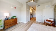 Located at 265 Avenue E SW in Winter Haven, Florida, this thoughtfully designed one-bedroom, one-bathroom residence makes excellent use of its compact footprint across a single floor. Light wood-tone flooring flows seamlessly throughout the entire space, creating a clean, cohesive aesthetic.

The galley-style kitchen is a standout feature, outfitted with crisp white cabinetry accented by matte black hardware, white quartz countertops, and a classic subway tile backsplash. Stainless steel appliances — including a dishwasher, electric range, and over-the-range microwave — provide a fully equipped cooking space. Track lighting overhead ensures ample illumination along the corridor.

The spacious primary bedroom is filled with natural light, thanks to a large sliding glass door that opens onto a private balcony with views of the surrounding neighborhood. A ceiling fan adds comfort, and a louvered closet door provides practical storage. The room's open, airy feel is enhanced by neutral wall tones and generous proportions.

The bathroom is clean and modern, featuring a white vanity with an undermount sink, a large mirror, and wood-look flooring that ties the space together. Multiple towel bars and a well-organized layout add to the room's functionality.

Overall, this residence offers a bright, modern living environment with thoughtful design details throughout.
