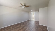 Located at 1217 Hillcrest St in Mesquite, TX, this single-story 1-bedroom, 1-bathroom home offers a compact and efficient layout across a well-utilized floor plan. The living room is an open, airy space featuring rich dark hardwood-style flooring, neutral gray walls, a textured ceiling, and a ceiling fan with light fixture — creating a comfortable and functional gathering area. A window with blinds allows natural light to brighten the space, adding to its welcoming feel. The kitchen is efficiently designed with light wood cabinetry, white countertops, a double stainless steel sink, a mosaic tile backsplash, and light tile flooring. It is equipped with a refrigerator and range, providing all the essentials in a clean, organized layout. The bedroom is a well-proportioned retreat, also finished with dark hardwood-style flooring and a ceiling fan. It connects directly to a dedicated walk-in closet featuring built-in shelving and hanging rods — offering ample storage. The bathroom includes a full tub-shower combo with white tile surround, complemented by tile flooring. Throughout the home, consistent finishes, clean white trim, and neutral tones create a cohesive and move-in-ready atmosphere.