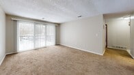 Located at 4285 Chestnut Ridge Rd in Buffalo, NY, this single-floor, three-bedroom, one-bathroom home offers a well-organized layout across a comfortable footprint. The interior features neutral, warm-toned walls and textured ceilings throughout, creating a consistent and cohesive aesthetic.

The kitchen is a functional highlight, outfitted with warm wood cabinetry, dark granite-style countertops, a tile backsplash, black appliances including a dishwasher and refrigerator, and durable hardwood-style flooring. An overhead light panel brightens the workspace effectively.

The three bedrooms are carpeted in a neutral tan tone, with the primary bedroom offering generous proportions and dual windows that bring in ample natural light. The additional bedrooms each feature at least one window with exterior views. A ceiling fan is present in one of the larger rooms, adding comfort and airflow.

The full bathroom includes a clean white soaking tub with built-in corner shelving and a window for natural ventilation.

A standout feature is the private balcony, accessible via sliding glass doors fitted with vertical blinds. The balcony overlooks a tree-lined neighborhood landscape, offering outdoor space and seasonal views. A hallway with hardwood-style flooring and a decorative stair railing connects the main areas of the home.