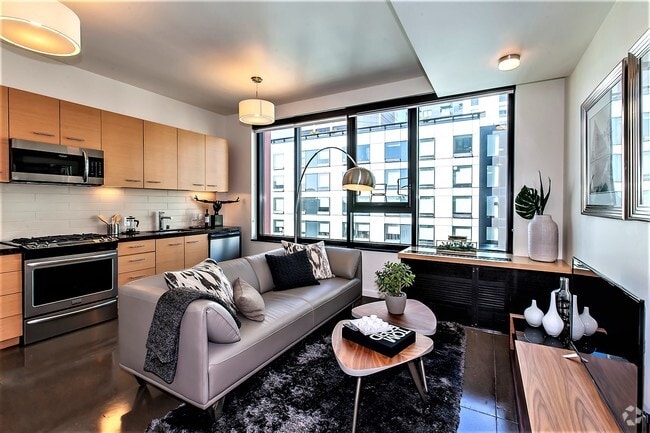 Modern living room with a view in a San Francisco apartment with the kitchen in the background. - Olume