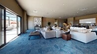 Located at 1 Gold St in Hartford, Connecticut, this single-floor amenity space offers a thoughtfully curated environment designed for both socializing and relaxation. The main lounge area is generously proportioned, furnished with plush, neutral-toned sectional sofas and accent chairs arranged around a sleek dark coffee table. Bold sculptural artwork and a striking large-scale text canvas serve as focal points, lending an artistic, gallery-like atmosphere throughout. Patterned blue carpeting grounds the space and adds a layer of visual texture.

Floor-to-ceiling glass doors line the perimeter, bathing the interior in abundant natural light while providing direct access to an open-air rooftop terrace. The terrace is finished with large-format white tile pavers and equipped with lounge chairs and casual seating, offering open views of the Hartford skyline.

A dedicated game room area features a shuffleboard table, billiards table, and additional seating, complemented by a curated gallery wall of contemporary artwork. The kitchen is outfitted with light wood and white cabinetry, a dark countertop, a marble-clad island with bar seating, and integrated appliances — ideal for entertaining. Additional transitional areas with decorative mirrors and built-in storage complete this refined, amenity-rich space.