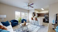 This single-story, one-bedroom, one-bathroom home offers a thoughtfully designed layout that maximizes its compact footprint. The open-concept living area is bright and welcoming, featuring wood-look flooring, neutral-toned walls, and large windows that allow generous natural light and outdoor views. A ceiling fan adds both style and function to the space. The living area flows seamlessly into the kitchen, which is outfitted with rich dark-wood cabinetry, light countertops, a mosaic tile backsplash, a double-basin sink, and a breakfast bar with seating — ideal for casual dining. The kitchen also benefits from a skylight and additional window, keeping the space bright. The bedroom is a comfortable retreat finished with plush carpet, a ceiling fan, and double closet doors providing ample storage. The full bathroom features a combined tub and shower, wood-look flooring, a dark-wood vanity with light countertops, and clean white walls that create a crisp, functional space. Additional spaces include an entrance, hallway, and dedicated closet, rounding out the home's practical design. Overall, the space presents a clean, modern aesthetic with consistent finishes throughout.
