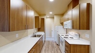 Located at 1032 Big Mountain Ave South in Salem, Oregon, this single-floor, three-bedroom, two-bathroom home offers a well-organized layout across a compact yet functional footprint. The entrance leads into a living area that transitions seamlessly into a combined dining room and kitchen. The kitchen is equipped with warm wood-toned cabinetry, white appliances including a range, microwave, refrigerator, and dishwasher, along with white countertops and a stainless steel sink. Wood-look hard flooring in the kitchen gives way to carpeting throughout the living and bedroom areas.

The three bedrooms feature neutral warm-toned walls, plush carpeting, and ample natural light from large windows that offer views of the surrounding neighborhood. Several bedrooms include closets with sliding doors and built-in hanging rods. Notably, at least one bedroom showcases vaulted ceilings, adding a sense of vertical openness. The primary bedroom provides a comfortable and private retreat.

The two bathrooms are finished with wood-look flooring, a vanity with white countertop, and chrome fixtures. One bathroom includes a walk-in shower with a glass door, while the other features a full soaking tub with a shower. An in-unit laundry room and four closets add practical storage throughout the home.