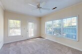 Located at 50 Carrington Ln in Douglasville, Georgia, this single-floor, one-bedroom, one-bathroom residence offers a well-organized and comfortable layout. The living room is a standout space, featuring plush carpeting, crown molding, a textured ceiling, and a ceiling fan. Large windows fitted with blinds on multiple walls flood the room with natural light and offer pleasant views of surrounding greenery, while a glass-panel door provides direct outdoor access. The open-concept design connects the living area seamlessly to the kitchen, which is highlighted by warm wood cabinetry, a peninsula breakfast bar, hardwood-style flooring, and an elegant chandelier overhead. The kitchen is well-appointed and includes a full suite of appliances. A dedicated laundry area is conveniently tucked adjacent to the kitchen. The spacious bedroom features soft carpeting, a ceiling fan, and a large window that brings in ample natural light with outdoor views. The full bathroom is finished with wood-tone cabinetry, a single-sink vanity with a light countertop, hardwood-style flooring, and clean, neutral walls. A dedicated closet provides additional storage. Throughout the home, a warm, neutral color palette and consistent finishes create a cohesive and inviting atmosphere.