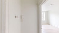Located at 2217 N 51st Street in Philadelphia, PA, this single-floor unit offers a thoughtfully organized layout comprising a bedroom, kitchen, and hallway. The bedroom is the largest space, featuring light-toned hardwood flooring, crisp white walls, and a classic panel-door closet that provides ample storage. Natural light filters in through double-hung windows, and a traditional cast-iron radiator underscores the building's character. Clean white trim and baseboards throughout lend a polished, well-maintained appearance.

The kitchen is efficiently arranged in a galley style, with warm honey-toned wood cabinetry, white quartz countertops, and a white subway tile backsplash that together create a clean, classic aesthetic. A stainless steel sink, gas range, and white refrigerator complete the functional setup, while a window above the counter brings in natural light and exterior views of the surrounding brick and stone architecture.

A connecting hallway links the bedroom and kitchen, creating a logical flow through the unit. Throughout the space, consistent light hardwood flooring and a neutral white palette contribute to a bright, cohesive atmosphere. This unit is ideal for those seeking a manageable, easy-to-maintain living space in a characterful Philadelphia neighborhood.