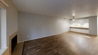 This two-bedroom, two-bathroom single-floor residence in Oregon City, OR offers a practical and comfortable layout across a well-utilized footprint. The combined living and dining area serves as the heart of the home, featuring rich dark hardwood-style flooring, a fireplace, and large windows alongside a glass door that flood the space with natural light and provide outdoor views. A ceiling fan adds to the comfort of the area, which flows openly toward the kitchen pass-through counter.

The kitchen is equipped with white cabinetry featuring brushed nickel hardware, stone-patterned countertops, and a stainless steel sink beneath a window. An adjacent pantry provides additional storage. In-unit laundry adds everyday convenience.

Both bedrooms are carpeted and finished in neutral gray tones, each featuring mirrored sliding closet doors and windows that bring in natural light. Baseboard heating is present in the bedrooms. The primary bedroom offers a comfortable, well-proportioned space.

The two bathrooms are cleanly finished with white cabinetry, stone-patterned countertops, and brushed nickel fixtures. One bathroom includes a shower-tub combination. A hallway connects the private areas of the home. Three closets throughout provide ample storage for everyday needs.