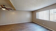 Located on Magnolia Ave in Riverside, CA, this single-floor, one-bedroom, one-bathroom unit offers a practical and comfortable layout. The living room is a bright, open space featuring wood-style plank flooring, neutral warm-beige walls, a textured ceiling, and a large window with vertical blinds that invites ample natural light. An adjacent dining area connects seamlessly to the kitchen, which is equipped with white cabinetry, light speckled countertops, a gas range, and wood-style flooring, providing generous counter and storage space. The bedroom is carpeted for comfort, with a window overlooking the exterior, a textured ceiling, and direct access to both a full bathroom and a closet. The bathroom features a clean, white tub-shower combination with chrome fixtures and a vanity with lighted mirror and white cabinetry. Three closets throughout the unit provide excellent storage capacity. Two utility areas add further functional versatility. The overall aesthetic is clean and neutral, with consistent warm-toned walls and a mix of wood-style and carpeted floors creating a cohesive, move-in-ready environment.