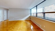 Located at 90 Tyndall Ave in Toronto's vibrant Parkdale neighbourhood, this one-bedroom, one-bathroom unit offers a well-organized single-floor layout. Warm parquet wood flooring runs throughout the living areas and bedroom, lending a classic character to the space. The open living room is bright and airy, anchored by a large floor-to-ceiling window that frames sweeping views of the Toronto skyline, including a glimpse of the iconic CN Tower, and fills the room with generous natural light. A baseboard heating unit runs along the window wall, ensuring comfort year-round. The kitchen is thoughtfully separated from the living area and features stainless steel appliances, a mosaic tile backsplash, white cabinetry, and tile flooring. It opens toward the living space for a connected feel. The bedroom is a comfortable, private retreat with parquet flooring, neutral walls, and a double-door closet providing ample storage. The bathroom is clean and functional, finished with white subway tile, a dark accent border, a soaker tub with overhead shower, and tile flooring. A private balcony with glass railings extends from the living area, offering elevated city and neighbourhood views — a standout feature of this well-appointed urban residence.