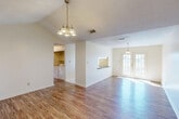 Located at 4802 Pontchartrain Dr in Slidell, Louisiana, this single-story, 2-bedroom, 1-bathroom home offers a practical and comfortable layout with thoughtful details throughout. The combined living and dining area forms the heart of the home, showcasing warm wood-look flooring, vaulted ceilings, and an elegant chandelier. Natural light pours in through French doors, which open to the outside and add a bright, airy feel to the space. A pass-through counter connects the living area to the kitchen, enhancing the open flow between rooms. The kitchen is well-appointed with warm wood cabinetry, dark countertops, tile flooring, and a full suite of appliances including a range, built-in microwave, and refrigerator. A window above the sink brings in additional natural light. Adjacent to the kitchen is a dedicated pantry and a laundry room with side-by-side washer and dryer hookups. The spacious primary bedroom features a large bay window and wood-look flooring, while the second bedroom offers a window and ample closet storage. The full bathroom is clean and functional, complete with a tub/shower combo, tile flooring, a vanity, and wood-tone wall cabinetry. A hallway with multiple closets provides generous storage throughout the home.