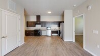Located at 7156 Barrington Dr in Charlotte, NC, this single-floor residence offers a thoughtfully designed layout with a clean, modern aesthetic. The open kitchen is a standout feature, showcasing rich dark-espresso cabinetry, light stone-look countertops, a decorative tile backsplash, a wall-mounted range hood, and a full suite of stainless steel appliances including a refrigerator, dishwasher, and electric range. Wood-look luxury flooring runs throughout the home, creating a cohesive and easy-to-maintain foundation.

The living area is bright and welcoming, with large windows fitted with horizontal blinds that invite natural light while maintaining privacy. A ceiling fan adds comfort, and double doors provide an additional connection to the outdoors. Bedrooms are generously sized, each with ample natural light from well-placed windows and access to closet space with built-in shelving and hanging rods.

The bathrooms cater to a range of needs. One features an accessibility-focused design with a tub-shower combination equipped with multiple grab bars and a fold-down bench seat, alongside a dark-cabinetry vanity with a stone-look countertop. A second bathroom offers a clean, straightforward tub-shower setup. The overall ambiance of the home is neutral, modern, and move-in ready.