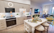 This contemporary 860 square foot apartment offers a thoughtfully designed living space with 3 bedrooms and 2 bathrooms. The open-concept layout seamlessly integrates the kitchen and living areas, creating a spacious feel. The kitchen boasts light wood cabinetry, stainless steel appliances, and a white tile backsplash, complemented by a central island that doubles as a dining space.

The bedrooms are bright and airy, with large windows allowing natural light to flood in. The primary bedroom, measuring 160 square feet, features a sliding glass door leading to an outdoor space. Bathrooms are modern and functional, with glass-enclosed showers, wood vanities, and ample storage.

Throughout the apartment, a cohesive design aesthetic is maintained with light wood flooring, white walls, and carefully curated artwork. Recessed lighting and strategically placed lamps contribute to the overall ambiance. The living room is comfortably furnished with a neutral-toned sofa and accent chairs, creating an inviting space for relaxation.

Despite its compact size, the apartment's clever design ensures every square foot is utilized effectively, offering a harmonious blend of style and functionality in the heart of Irvine, California.