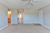 This single-floor home in Warner Robins, Georgia offers a practical and comfortable layout designed for everyday living. The common areas and kitchen feature warm hardwood-style flooring, while the bedrooms are finished with plush wall-to-wall carpeting in neutral tones, creating a cozy atmosphere throughout.

The kitchen is well-appointed with an abundance of light wood cabinetry providing ample storage, a tile backsplash, laminate countertops, and a full suite of white appliances including a range, over-the-range microwave, dishwasher, and refrigerator. Overhead lighting keeps the space bright and functional.

Each bedroom is generously sized with neutral gray walls, carpet flooring, and ceiling fans with light fixtures. The primary bedroom includes direct access to a private bathroom and benefits from natural light through a window. Additional bedrooms are similarly sized and well-lit with windows overlooking the outdoors.

The bathrooms feature tub-shower combinations with clean white surrounds. A dedicated utility room houses the water heater, electrical panel, and built-in shelving, adding convenient storage. Textured ceilings are consistent throughout the home, and white trim provides a clean finish to each room. The overall ambiance is neutral, move-in ready, and well-maintained.