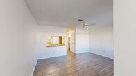 Located at 1920 SW 31st Ave in Ocala, Florida, this single-story, one-bedroom, one-bathroom unit offers a practical and well-organized layout. Wood-look flooring runs consistently throughout the entire space, providing a clean and cohesive aesthetic.

The open living area is bright and airy, featuring a ceiling fan with integrated lighting and neutral white walls that maximize the sense of space. A pass-through window with a wooden countertop connects the living area to the kitchen, creating an open sightline between the two spaces. The galley-style kitchen is efficiently designed with ample white cabinetry, wooden countertops, a double sink, and white appliances including a refrigerator and electric range with hood.

The spacious primary bedroom accommodates comfortable living with a ceiling fan, a window allowing natural light and outdoor views, and a sliding glass door that opens to the exterior — bringing in additional light and a connection to the surrounding greenery. The bedroom also benefits from two closets, offering generous storage.

The full bathroom features a combined tub and shower with tile surround, a vanity with storage, and matching wood-look flooring. Textured ceilings are present throughout the unit, contributing to the classic Florida residential character of this well-maintained home.