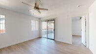 Located at 850 S Longmore in Mesa, AZ, this single-floor, one-bedroom, one-bathroom unit offers a clean, modern aesthetic throughout. Light wood-style flooring flows seamlessly across all living areas, complemented by crisp white walls and bright, natural light admitted through multiple windows and vertical blinds.

The combined kitchen and living area forms the heart of the unit. The kitchen is outfitted with white flat-panel cabinetry, dark granite-style countertops, a stainless steel refrigerator, range, and over-the-range microwave, alongside a single-basin sink — providing a functional and contemporary cooking space that opens directly into the living area.

The living room features a ceiling fan with light fixture and a sliding glass door with vertical blinds that leads to an outdoor area, enhancing the sense of openness. The bedroom is a comfortable size, also equipped with a ceiling fan, a sliding glass door for outdoor access, and additional windows that bring in ample natural light.

The bathroom includes a granite-topped vanity with an undermount sink, a large mirror, and a separate water closet housing the toilet and shower-tub combination. A dedicated laundry area with a full-size top-loading washer and dryer adds everyday convenience. A closet completes the well-organized layout of this efficiently designed unit.