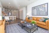 Located at 1850 Duluth Hwy in Lawrenceville, Georgia, this single-floor residence offers a thoughtfully designed layout with contemporary finishes throughout. The open-concept kitchen is a standout feature, showcasing granite countertops, light wood cabinetry with matte black hardware, a subway tile backsplash, and a full suite of stainless steel appliances. A peninsula with bar seating and pendant lighting creates an inviting space for casual dining and entertaining.

The living area is warm and welcoming, with wood-look flooring, a ceiling fan, large windows that admit generous natural light, and a teal accent wall that adds a modern pop of color. The space comfortably accommodates a full seating arrangement and media setup.

The primary bedroom features plush carpeting, a ceiling fan, and ample natural light from well-dressed windows. It connects to a spacious walk-in closet and a private en-suite bathroom finished with granite counters, wood-toned cabinetry, hardwood-style flooring, and a glass-enclosed shower. A second bedroom offers similar comfort, highlighted by a textured accent wall and its own ceiling fan. The second bathroom includes a full tub-shower combination with white subway tile and a granite vanity, maintaining the cohesive, refined aesthetic found throughout the home.