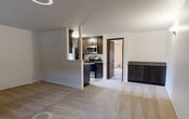 This contemporary apartment, located at 522 N I St. - Unit 301 in Tacoma, WA, offers a blend of comfort and functionality. The open floor plan seamlessly integrates the living, dining, and kitchen areas, creating a spacious feel. Plush carpeting in a neutral tone covers most living spaces, while the kitchen boasts wood-look flooring.

The kitchen is a standout feature, with dark wood cabinetry contrasting beautifully against light countertops. Stainless steel appliances and a convenient breakfast bar complete the modern culinary space. Large windows throughout the apartment, including a sizable one in the living room, flood the interior with natural light and offer views of the surroundings.

The bedroom areas are generously sized, with ample closet space indicated by mirrored sliding doors. A private balcony, accessible through a dark wood door, provides outdoor living space. The bathroom features a clean, white aesthetic with a combination tub/shower, single vanity, and modern fixtures.

Additional amenities include central heating and cooling, as evidenced by visible vents. The apartment's neutral color palette of whites and beiges creates a versatile canvas for personal decor styles. Overall, this unit offers a comfortable, modern living space in a prime Tacoma location.