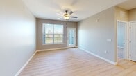 Located at 4005 State Farm Parkway in Columbia, MO, this well-appointed 2-bedroom, 2-bathroom unit offers a thoughtfully designed, single-level layout. The open-concept kitchen and living area serves as the heart of the home, where a white-topped center island with pendant lighting connects seamlessly to the living room. The kitchen is outfitted with dark cabinetry, stainless steel appliances including a refrigerator, range, and microwave, and light wood-style flooring that continues throughout the unit. The living room features a ceiling fan and windows that look out to a private balcony, filling the space with natural light. Both bedrooms are comfortably sized, with the primary bedroom benefiting from dual windows and its own ceiling fan. Each bedroom is complemented by a dedicated closet, including a walk-in closet with built-in shelving and hanging rods. The two bathrooms are finished with dark wood vanities, white countertops, and light wood-style flooring. One bathroom features an elongated vanity layout with a walk-in shower, while the second offers a clean, functional design. Neutral wall tones and consistent flooring throughout give the unit a cohesive, modern aesthetic.