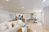 Located at 805 Roosevelt in Boise, Idaho, this thoughtfully designed 2-bedroom, 2-bathroom residence offers a seamless blend of modern aesthetics and functional living. The single-floor layout centers around a bright, open-concept living, dining, and kitchen area unified by light hardwood flooring and a neutral color palette that enhances the sense of space. The kitchen is a standout, featuring warm wood cabinetry with brushed gold hardware, white quartz countertops, a waterfall island with bar seating, glass pendant lighting, and a full suite of stainless appliances with a classic tile backsplash. The dining area is anchored by a striking circular chandelier and receives generous natural light through large windows with clean-lined blinds. The living area is airy and comfortable, complete with a wall-mounted mini-split system for year-round climate control. The primary bedroom offers a calm retreat with plush carpeting, and its en-suite bathroom includes a glass-enclosed shower and a walk-in closet with built-in shelving. The second bathroom features floor-to-ceiling tile, a deep soaking tub, and brushed nickel fixtures. Additional spaces include a pantry, laundry room, hallway, and multiple closets, completing this well-appointed Boise residence.